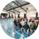 Students sat in a circle in the sports hall.